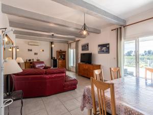 サンタ・ルシア・ディ・モリアニにあるHoliday Home La Cerisaie by Interhomeのリビングルーム(赤いソファ、テレビ付)
