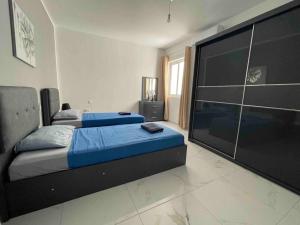 um quarto com 2 camas e uma grande televisão de ecrã plano em 2 bedroom Apartment in Mellieha with Sea Views and Close to all Amenities em Mellieħa