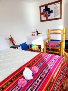 1 dormitorio con cama, mesa, mesa y sillas en Amantani Lodge, en Ocosuyo