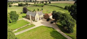 an aerial view of an old house in a field at The Cobbles in Towcester