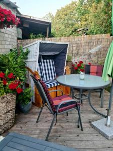 a patio with a table and chairs and flowers at Ferienappartement Ückeritz Usedom in Ueckeritz