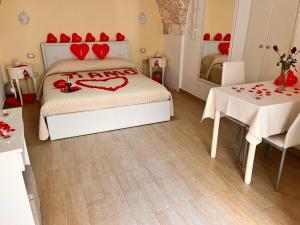 una camera da letto con un letto con cuori rossi sopra di CASA LARI a Martina Franca