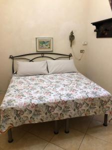 a bed with a floral quilt on it in a bedroom at Appartamento Via Rezzano vista mare in Bonassola