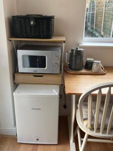 un four micro-ondes assis sur un comptoir à côté d'une table dans l'établissement Exclusive use of Garden Room!!, à Bristol