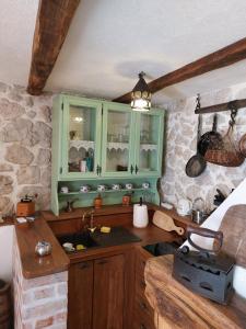 una cocina con armarios verdes y fregadero en Apartman Lidija, en Makarska