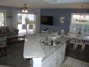 a kitchen and living room with a sink and a counter at Brunswick Plantation Villa 1203 with Full Kitchen, Golf Course Onsite, and Short Drive to the Beach villa in Calabash