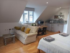 a living room with a couch and a table at Oak Loft in Lyme Regis