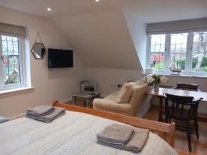 una camera con due letti, un divano e un tavolo di Oak Loft a Lyme Regis