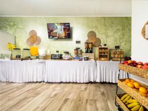 uma mesa longa com cortinas brancas e fruta em The Flamingo em Hollywood