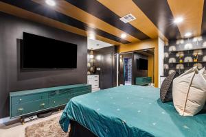 a bedroom with a bed with a tv on the wall at The Ritz - Luxury Home with Pool & Speakeasy Bar in Palm Springs