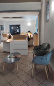 een woonkamer met 2 stoelen en een tafel bij Hotel Restaurant Miramar L'orchidée in La Ciotat