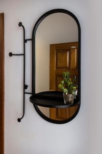 a black mirror hanging on a wall with a plant at Impar Studios Deluxe in Porto