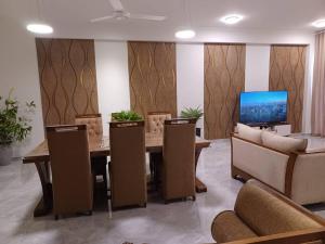 ein Esszimmer mit einem Tisch, Stühlen und einem TV in der Unterkunft Luxury 3 Bedrooms Apartment in Colombo in Sri Jayewardenepura Kotte