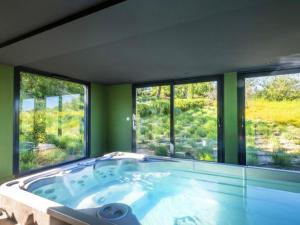 a large bath tub in a room with windows at Studio avec piscine partagee et wifi a Forcalquier in Forcalquier