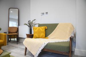a green couch with a yellow pillow on it at Lux 3BDR for 7 nr London Eye in London