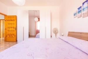 1 dormitorio con 1 cama grande con colcha rosa en Salentoandmore - Casa Anna, en Salve