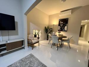 a living room with a table and chairs and a television at Stunning 3-Br Apt in Condado in San Juan
