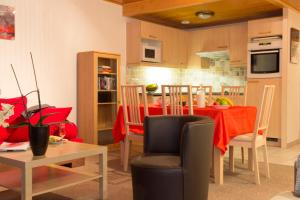 a kitchen and living room with a table and chairs at La Résidence Belledonne in Courchevel