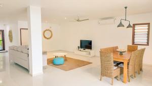 uma sala de estar com uma mesa e um sofá em Paradise Point Escape em Port Vila