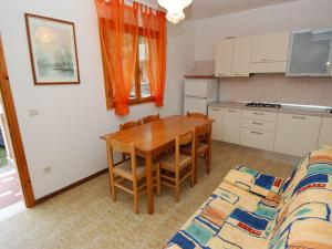 eine Küche und ein Esszimmer mit einem Tisch und einem Sofa in der Unterkunft Apartment Casa Lucrezia-1 by Interhome in Rosolina Mare