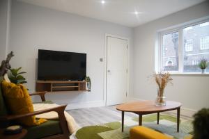 a living room with a tv and a table at Lux 3BDR for 7 nr London Eye in London