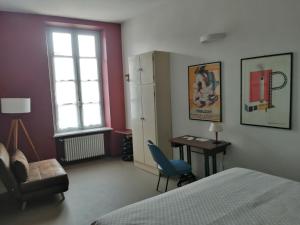 a bedroom with a bed and a desk and a window at L' estate di san Martino Room Rental - free park in Asti