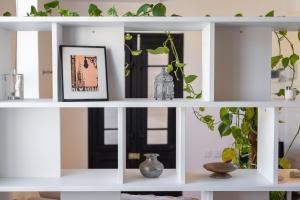 un estante blanco con plantas y un cuadro en Roam Gozo - Studio Hamrija - Modern Cozy Tiny Home Set In Gozo's Oldest Village, en Xewkija