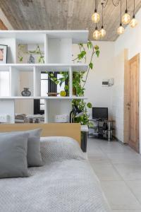 un dormitorio con una cama y algunas plantas en ella en Roam Gozo - Studio Hamrija - Modern Cozy Tiny Home Set In Gozo's Oldest Village, en Xewkija