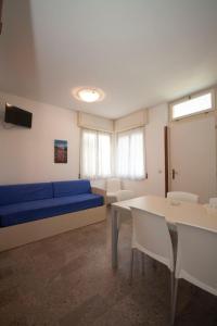 un soggiorno con divano blu e tavolo di Apartment Diana by Interhome a Bibione