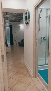 La salle de bains est pourvue d'une douche et d'une porte en verre. dans l'établissement I Tesori di Napoli, à Naples