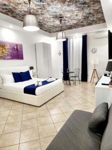 a bedroom with a white bed with a blue blanket at I Tesori di Napoli in Naples
