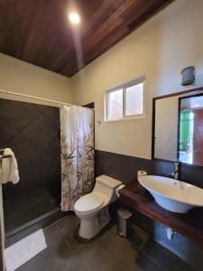 y baño con aseo, lavabo y ducha. en Kayu Surf Resort, en La Libertad