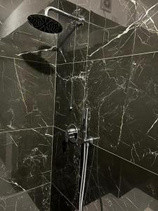uma casa de banho com um chuveiro e uma parede em mármore preto em Casa comfort zone em Perugia