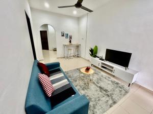 sala de estar con sofá azul y TV en Home288#2pax#wifi#NearAeonAlma#5kmtoIconCity en Bukit Mertajam