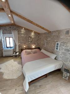 ein Schlafzimmer mit einem großen Bett und einer Steinmauer in der Unterkunft Apartman Lidija in Makarska