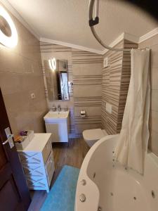 a bathroom with a tub and a toilet and a sink at Apartman Lidija in Makarska