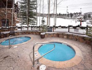 a hot tub in a courtyard with snow on the ground at Snowcloud 302SC in Avon