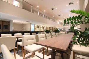 a conference room with a wooden table and white chairs at Samba Linhares in Linhares