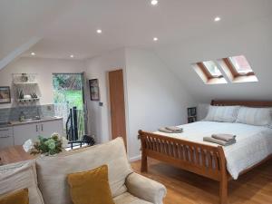 a bedroom with a bed and a couch and a kitchen at Oak Loft in Lyme Regis