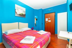 una camera blu con un letto e asciugamani di Affittacamere Grugliasco Ressia a Grugliasco