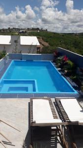 una grande piscina blu con due sedie accanto di Casa Bouganville a Monte das Gameleiras