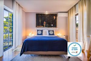 a bedroom with a blue bed and a painting on the wall at 7 bedrooms villa with private pool enclosed garden and wifi at Sesimbra in Sesimbra