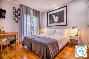1 dormitorio con cama, escritorio y ventana en 7 bedrooms villa with private pool enclosed garden and wifi at Sesimbra en Sesimbra