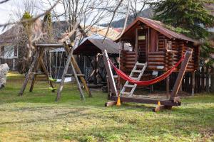 a log cabin with a swing and a playground at Bucovina Flower in Câmpulung Moldovenesc