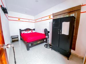 a bedroom with a red bed in a room at Palomino Hostel in Palomino