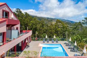 una piscina sul lato di un edificio di Comfortable apartment with shared pool in Prazeres, 150 m² a Campanário