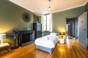 1 dormitorio con cama blanca y chimenea en Magnifique appartement en Hypercentre, en Burdeos