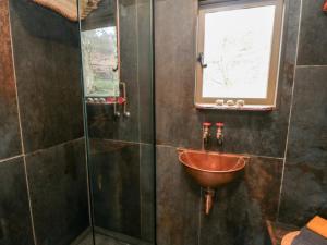 baño con lavabo y ventana en The Hideaway, Shepherd's Hut, en Scarborough