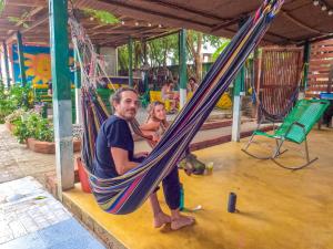 Palomino Hostel في بالومينو: رجل و بنت صغيرة يجلسون على أرجوحة