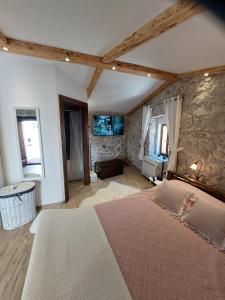 a bedroom with a large bed and a stone wall at Apartman Lidija in Makarska